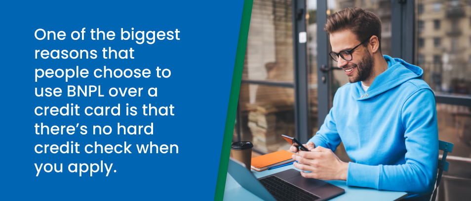 One of the biggest reasons that people choose to use BNPL over a credit card is that there's no hard credit check when you apply -  Image of a man in front of his laptop holding his cell phone